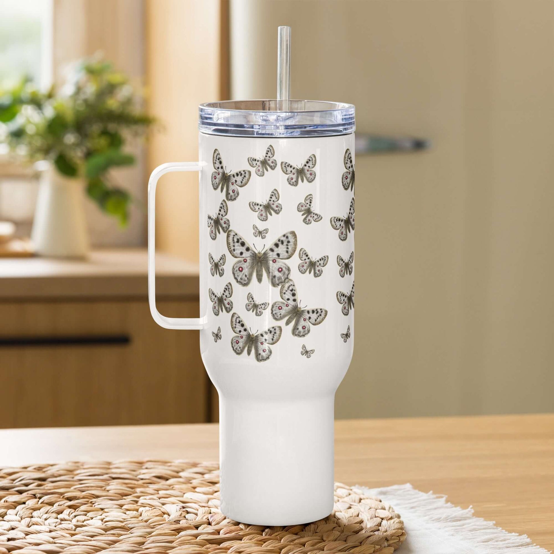 Apollo Butterfly Design Tumbler in white, 25oz/40oz, with straws and handles on a kitchen table. Perfect travel coffee mug.