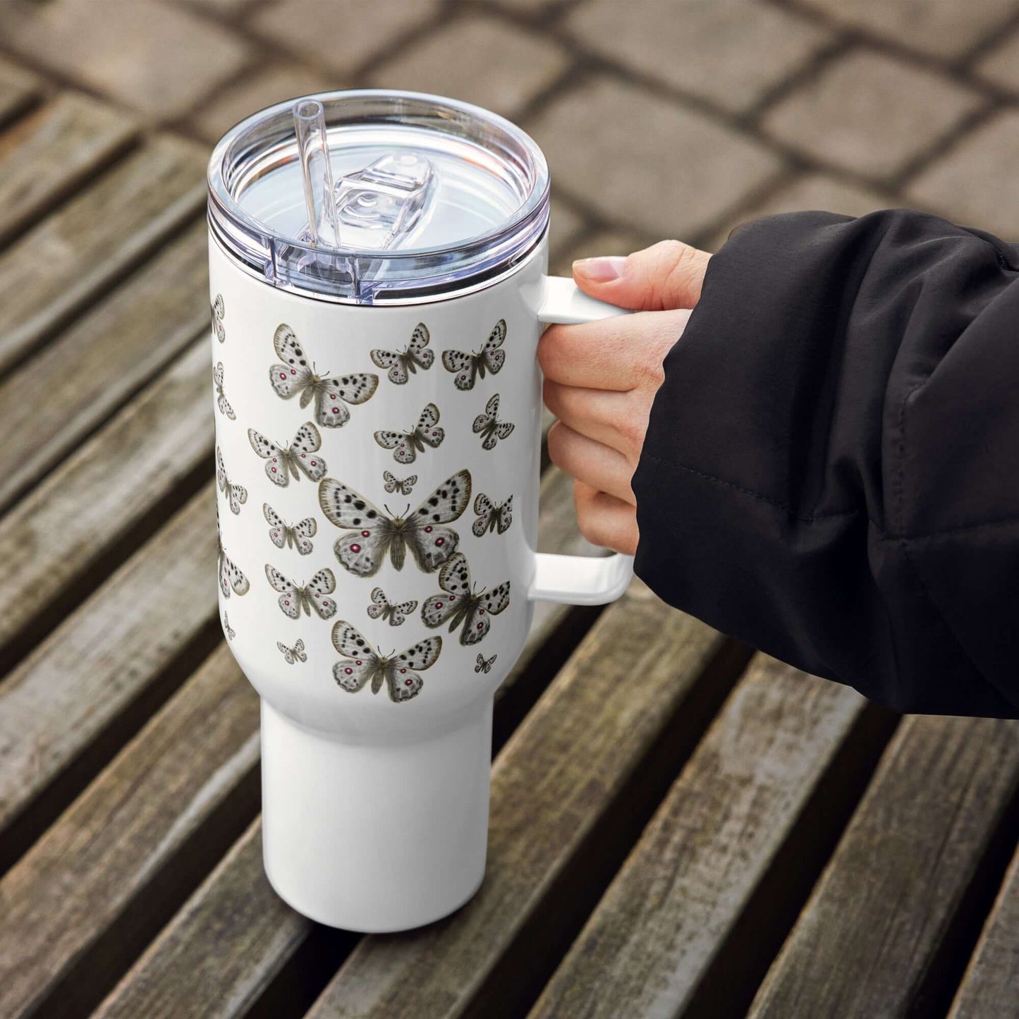 Apollo Butterfly Design Tumbler with lid and straw, 25oz or 40oz, held in hand on wooden surface.