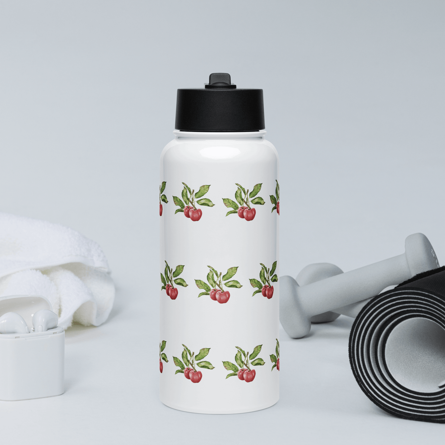 Bright Cherry insulated tumbler with cherry design next to gym accessories and towel, ideal for fitness enthusiasts.