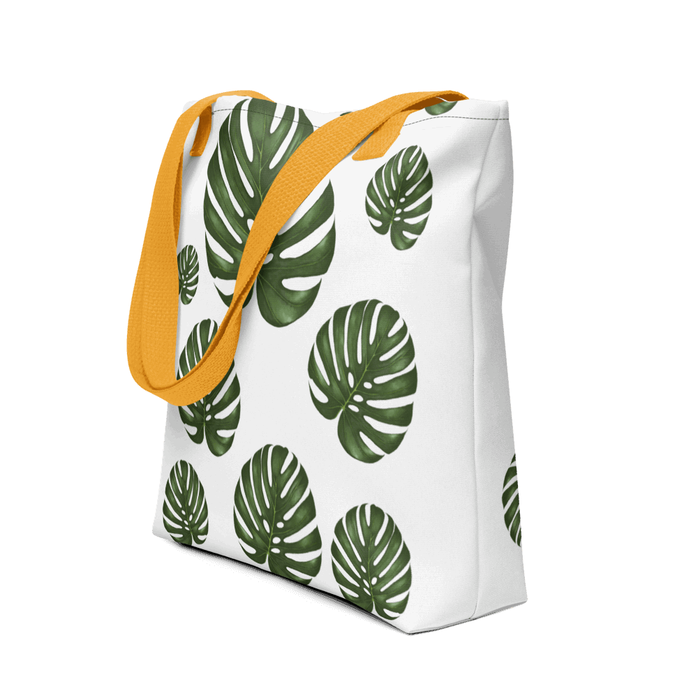 Monstera all-over print tote bag with yellow handles displayed prominently