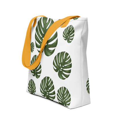 Monstera all-over print tote bag with yellow handles displayed prominently