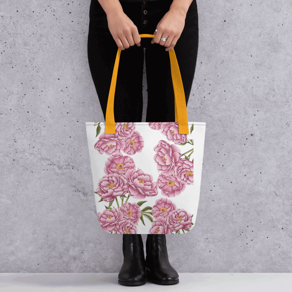 Peony all-over print with yellow handles held by a person dressed in black with both hands holding it in front