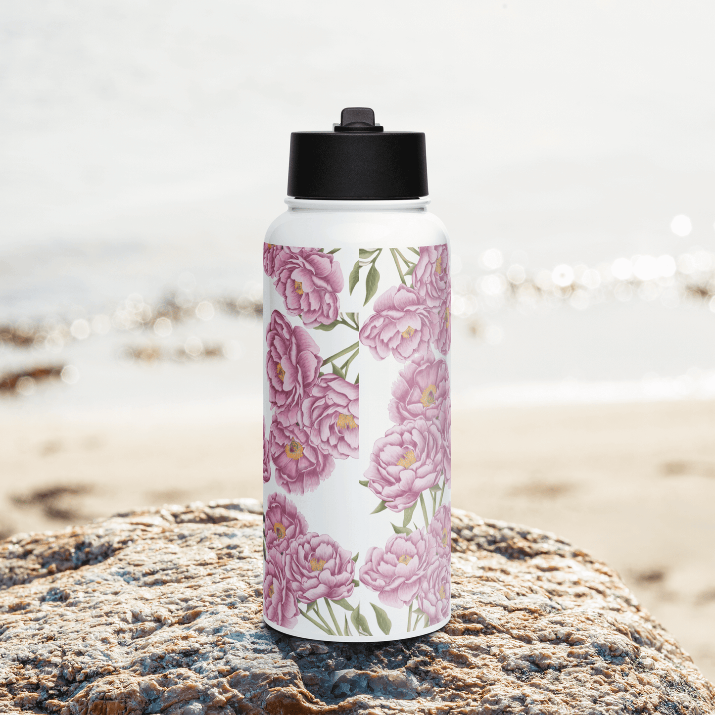 Romantic peony water bottle against a beach backdrop, showcasing floral design perfect for gifts and hydration.