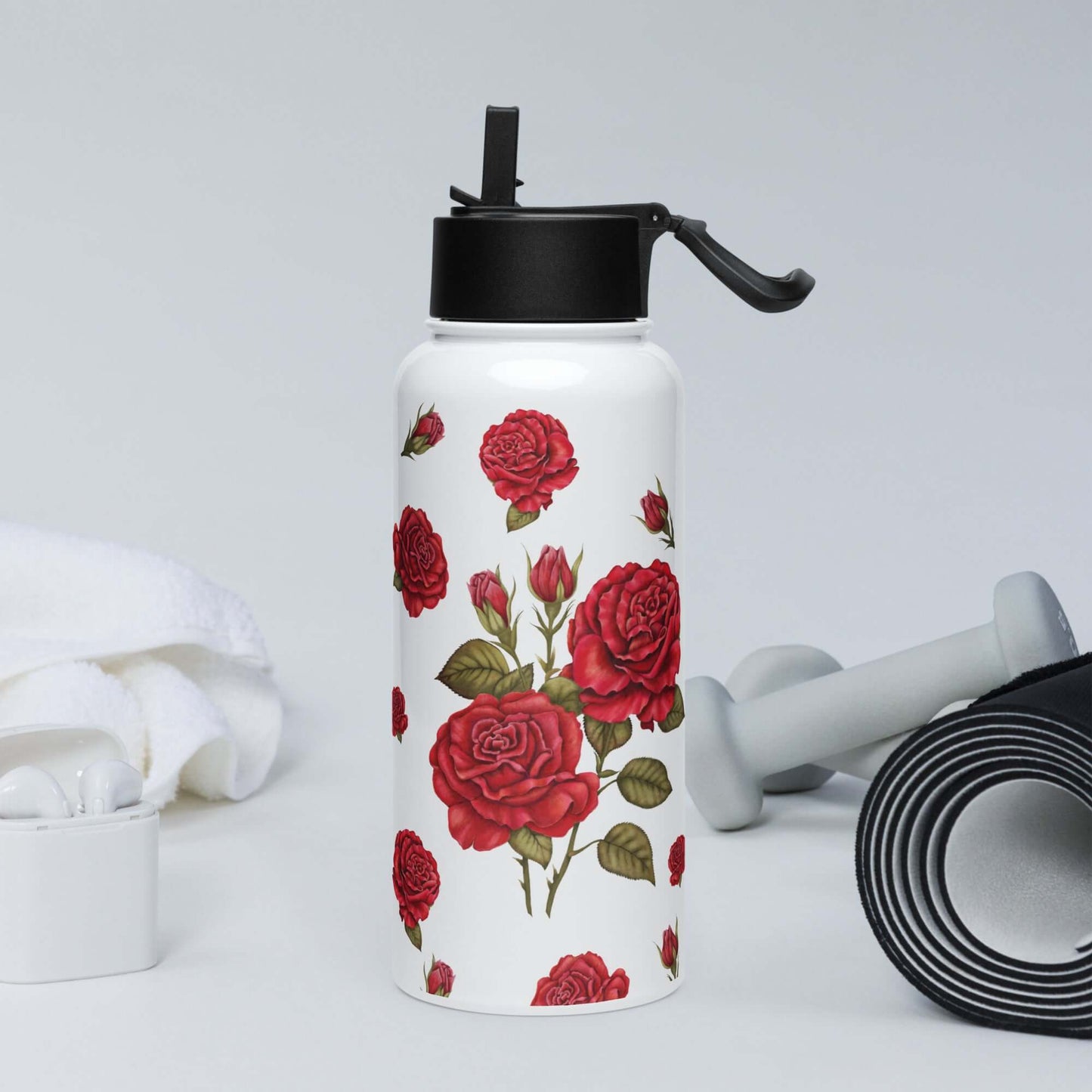 An energetic rose water bottle sits in a gym setting, its subtle yet romantic red rose design adding a touch of elegance to the workout space.