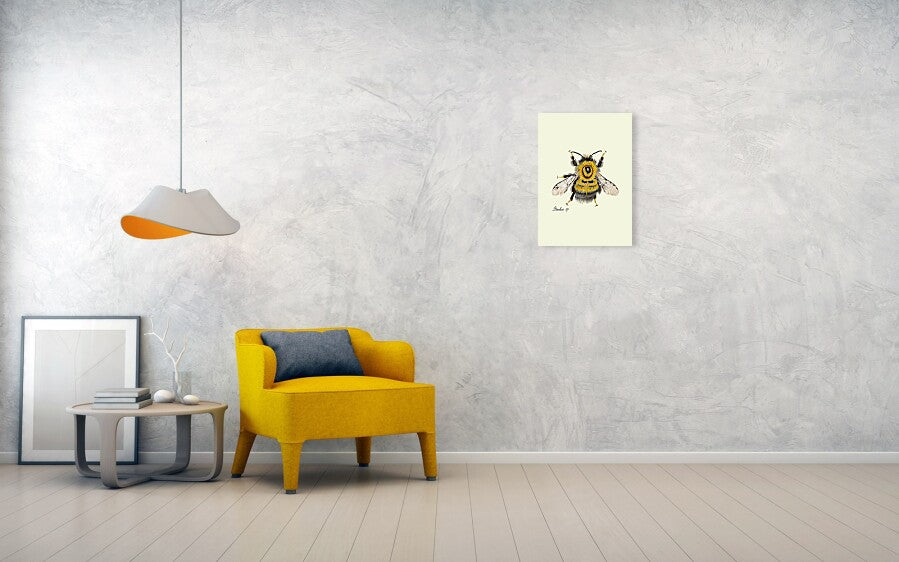 bumblebee art print hanging on a grey wall next to a yellow chair. 