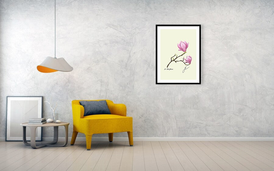 magnolia fine art print with black frame hanging on a wall next to a yellow sofa and a lamp